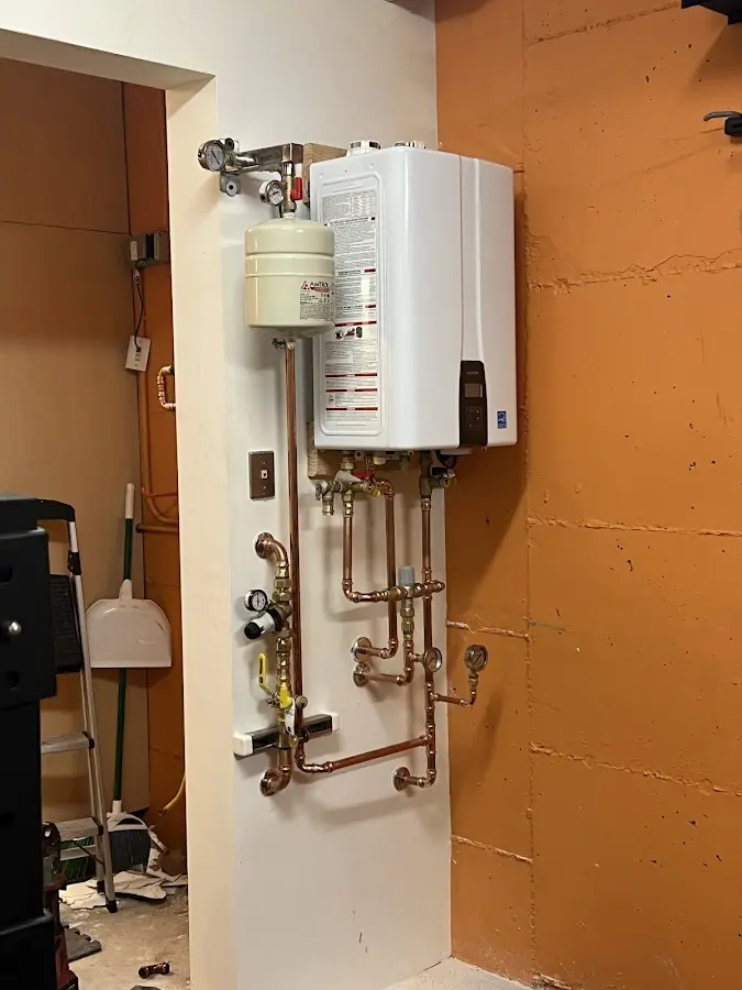 Plumbing technician inspecting water heater connections in Kerrville
